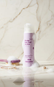 Product labeled 'Her Chamber' on a marble surface with a brush and other items.